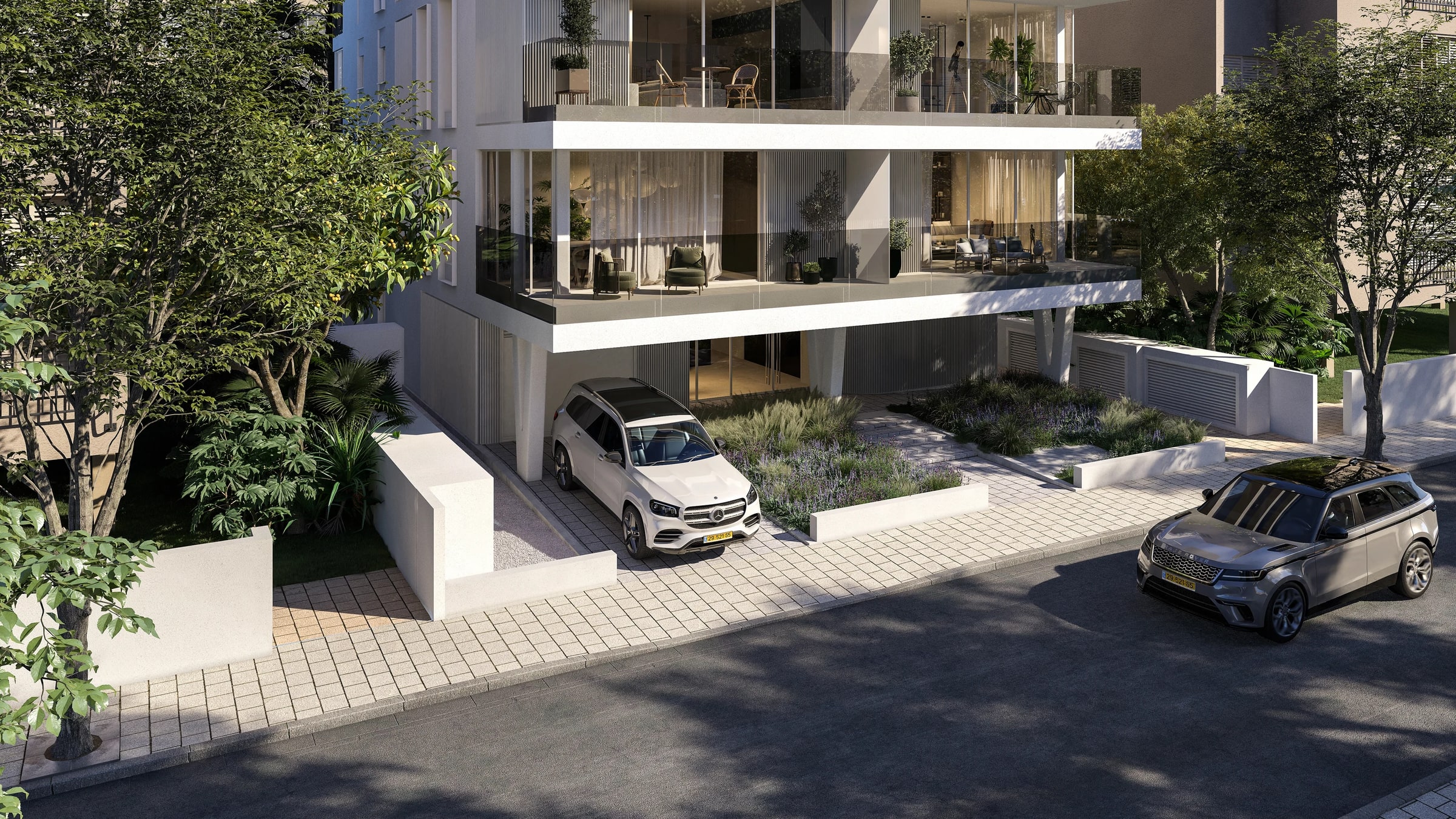 A quiet residential street in the Old North of Tel Aviv, shaded by mature trees, with planting along the pavement.